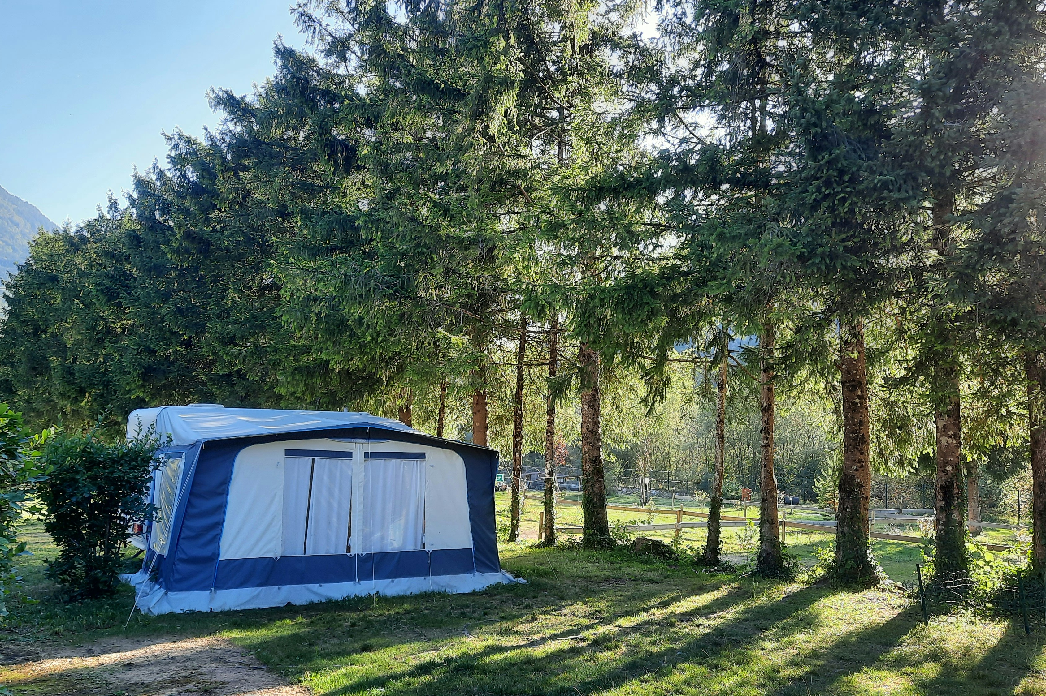 Camping Le Valserine - Standplätze zwischen den Bäumen auf dem Campingplatz