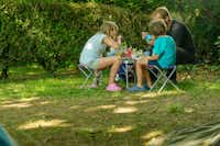 Camping Le Vaugrais - Familie beim gemeinsamen Essen auf ihrem Stellplatz