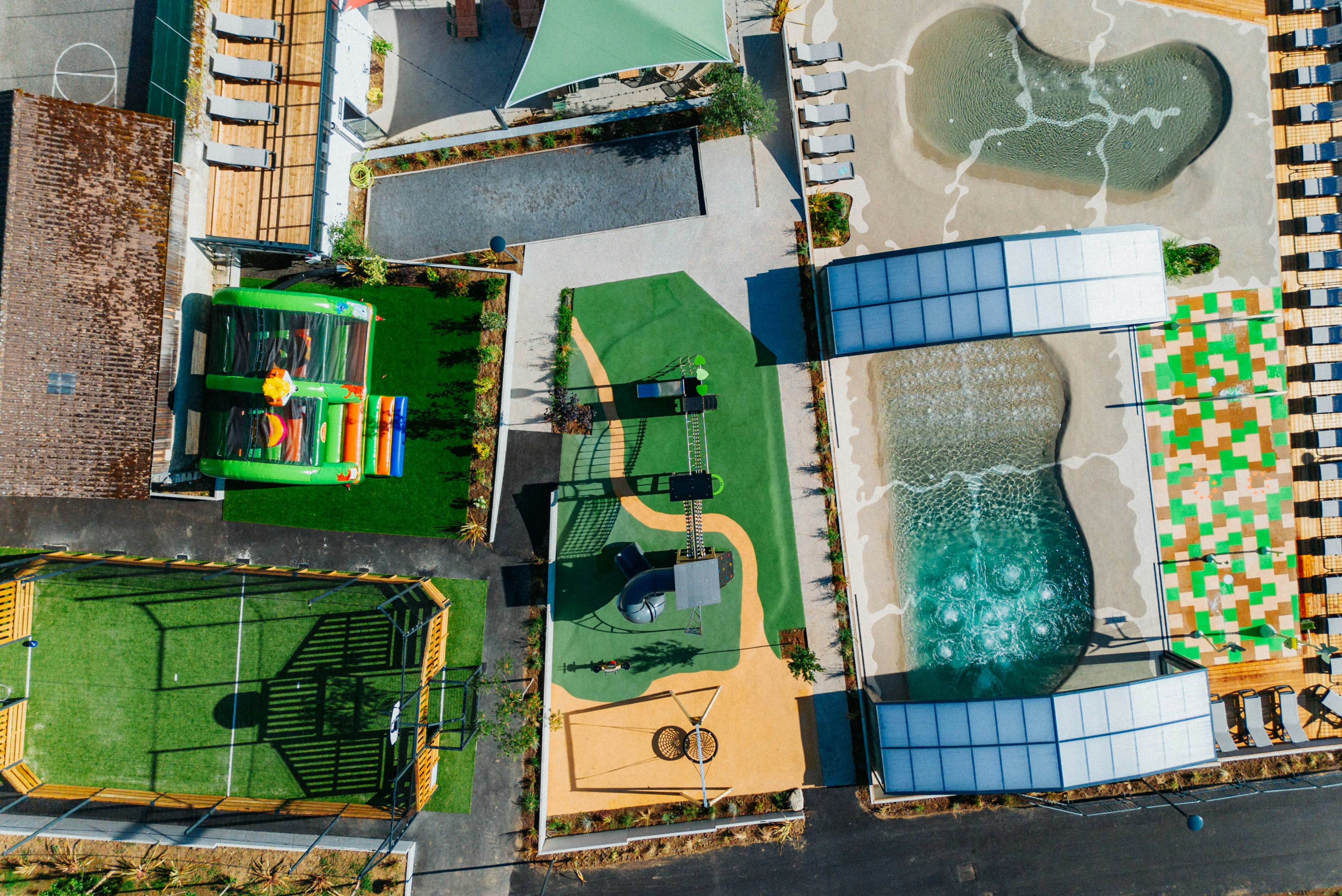 Yelloh! Village Lo Velâjo  Camping Le Verger Fleuri  - Luftaufnahme des Campingplatzes mit Sportplätzen, Kinderspielplatz und Freibad
