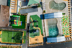 Yelloh! Village Lo Velâjo Camping Le Verger Fleuri - Luftaufnahme des Campingplatzes mit Sportplätzen, Kinderspielplatz und Freibad