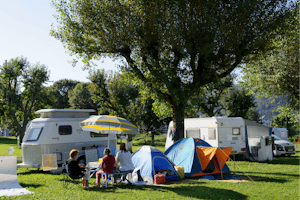 Camping Le Vieux Berger - Sitzende Gäste vor dem Zelt auf der Wiese der Campingplatzanlage