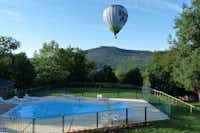Camping Le Viginet - Campingplatz Pool und Heißluftballon am Himmel