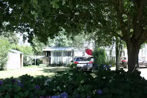 Camping Le Village de Florine - Wohnwagen- und Zeltstellplatz zwischen Bäumen auf dem Campingplatz