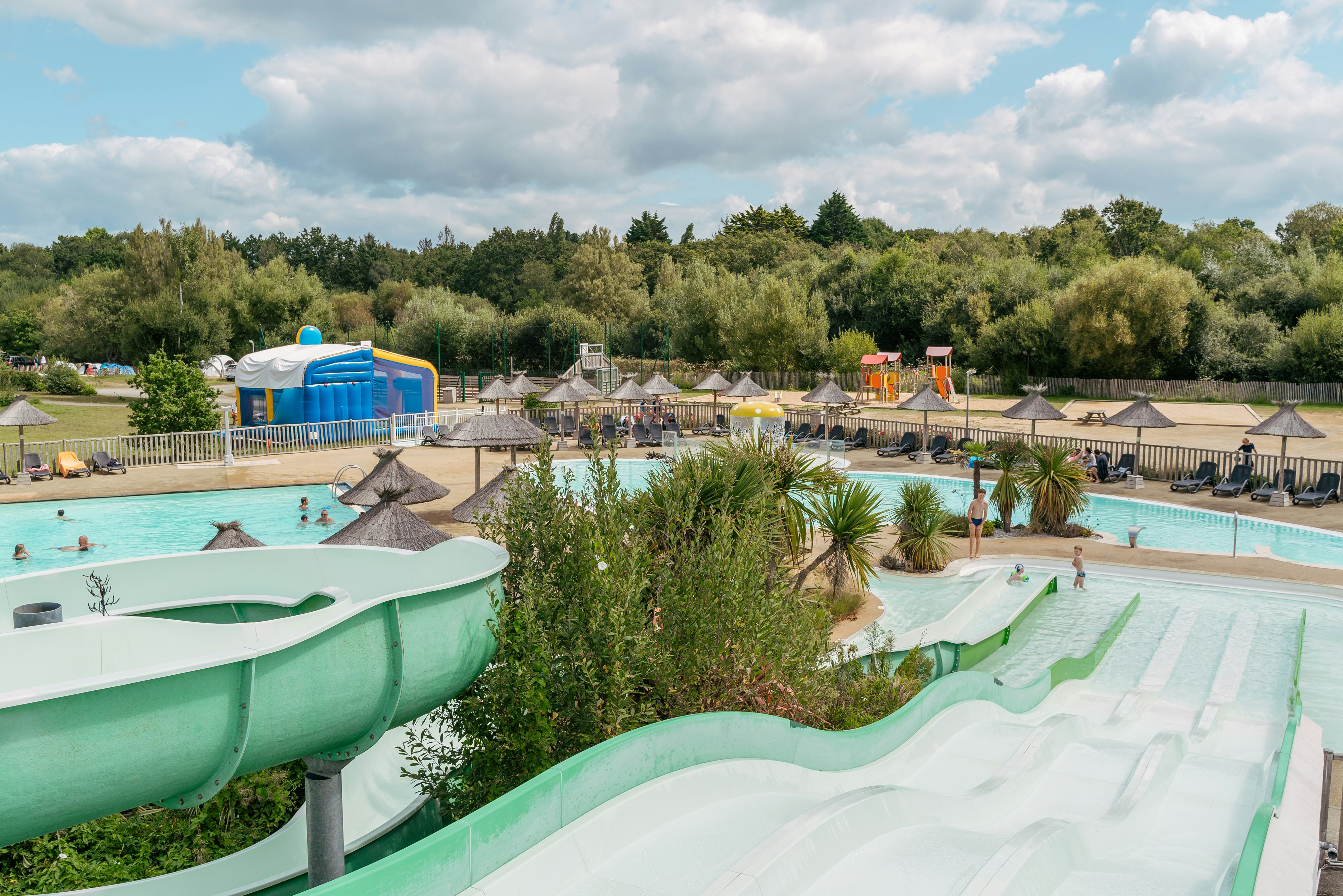 Flower Camping Le Vorlen  - Pool im Freien mit Wasserrutschen, Liegestühlen und Sonnenschirmen