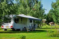 Camping Leiputrija - Wohnwagen auf einem Stellplatz zwischen Bäumen