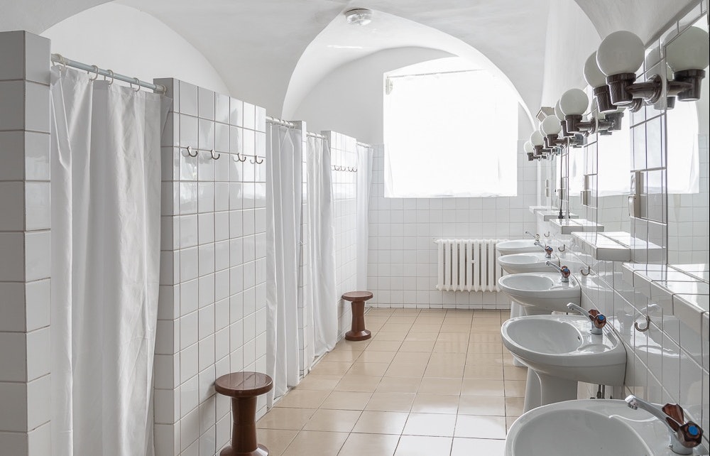 Camping Leśny Dwór -  Waldgut - Innenansicht des Sanitärgebäudes mit Waschbecken und Duschkabinen