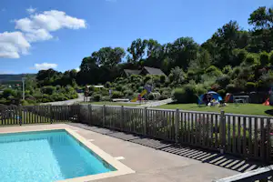 Camping Les 12 Cols - Swimmingpool auf dem Campingplatz mit ZEltwiese und Spielplatz im Hintergrund