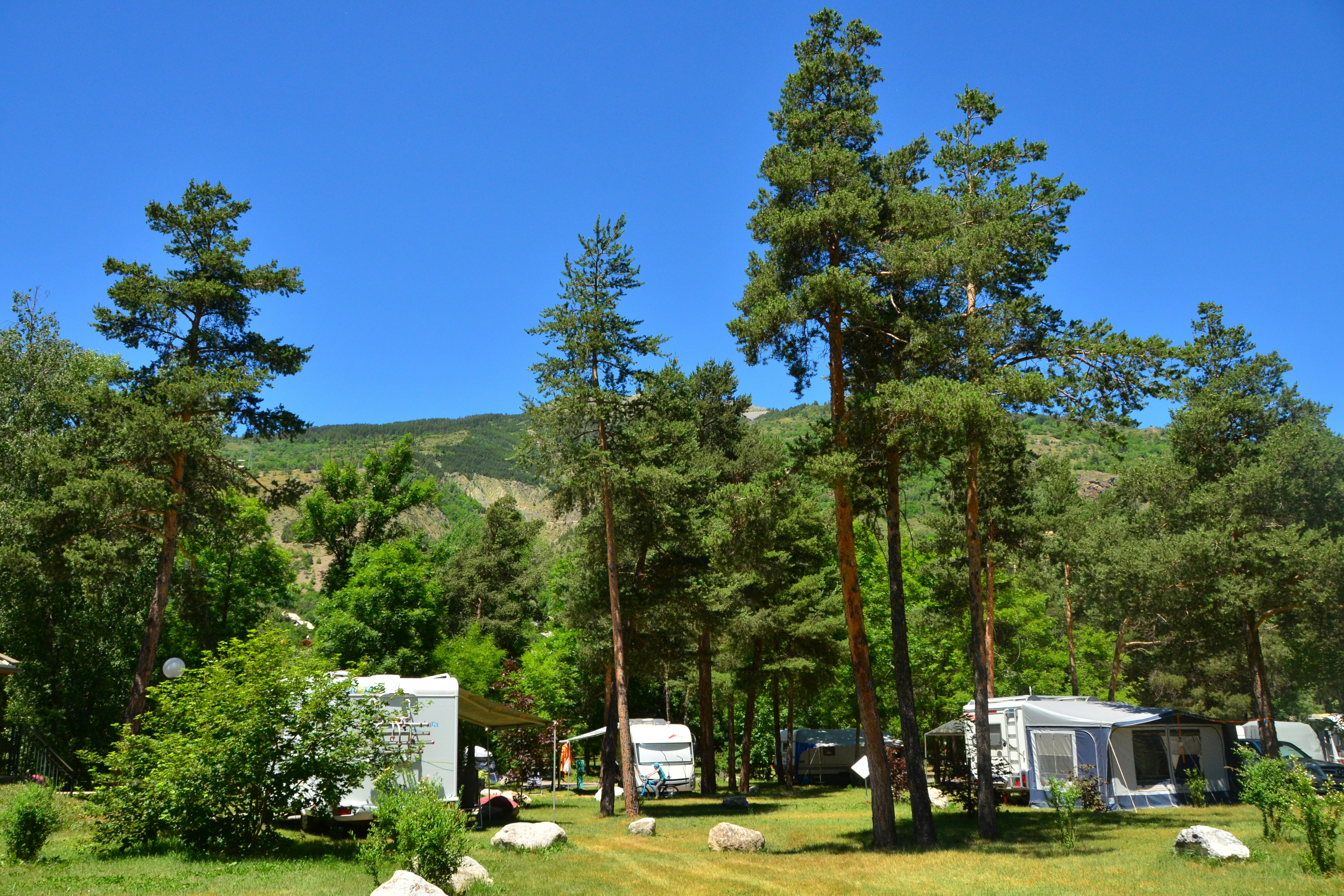 Camping Les 5 Vallées - Standplätze unter Bäumen auf grüner Wiese