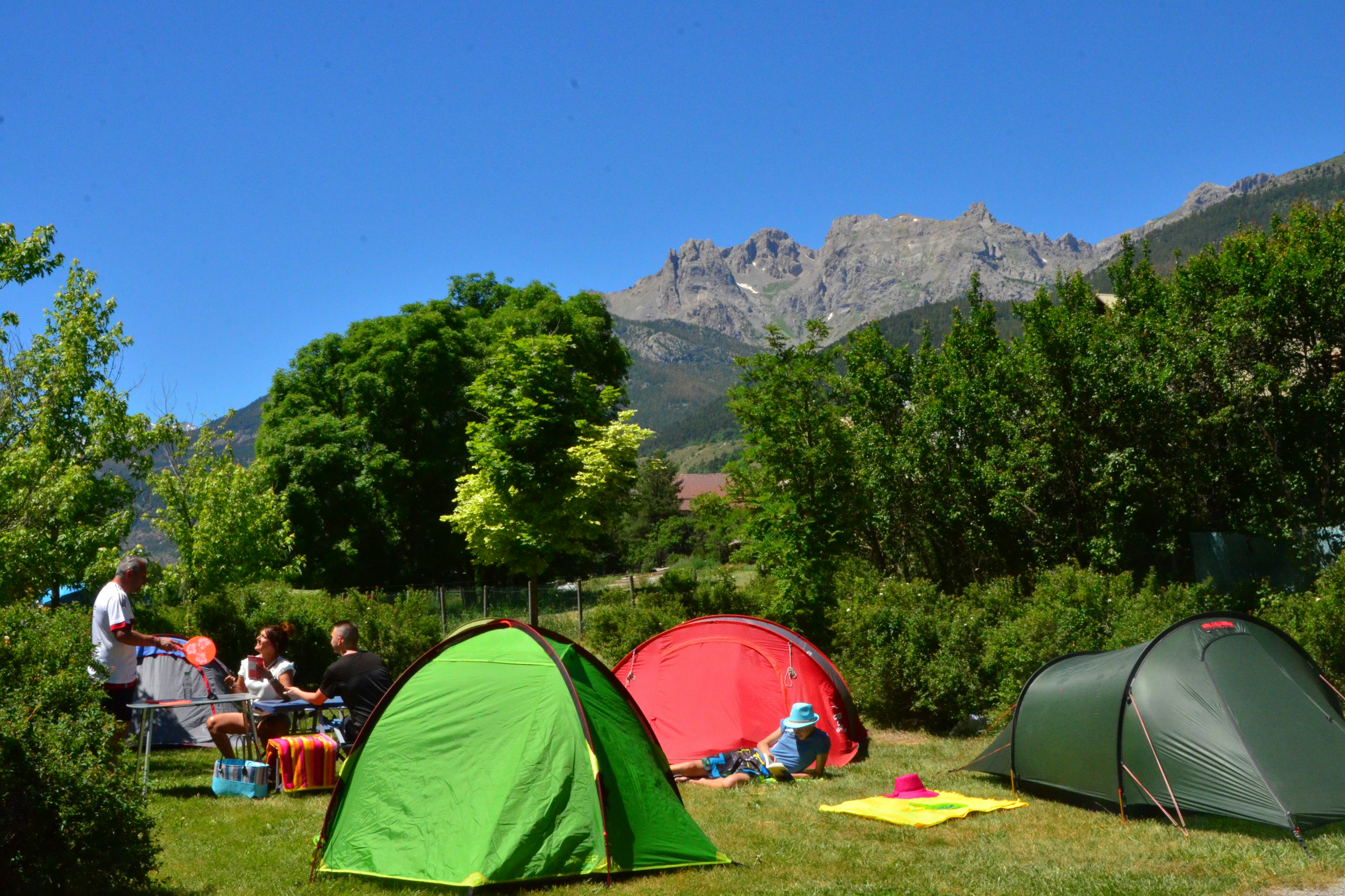 Camping Les 5 Vallées - Zeltplatz auf grüner Wiese umgeben von Hecken