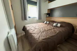 Camping Les Acacias - Doppelbett im Schlafzimmer eines Mobilheims