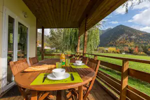 Camping Les Auches - überdachte Veranda eines Mobilheims mit Esstisch