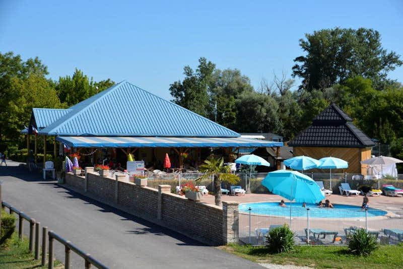 Camping Les Bords de la Loue - Campingplatz mit Pool, Liegestühlen und Sonnenschirmen