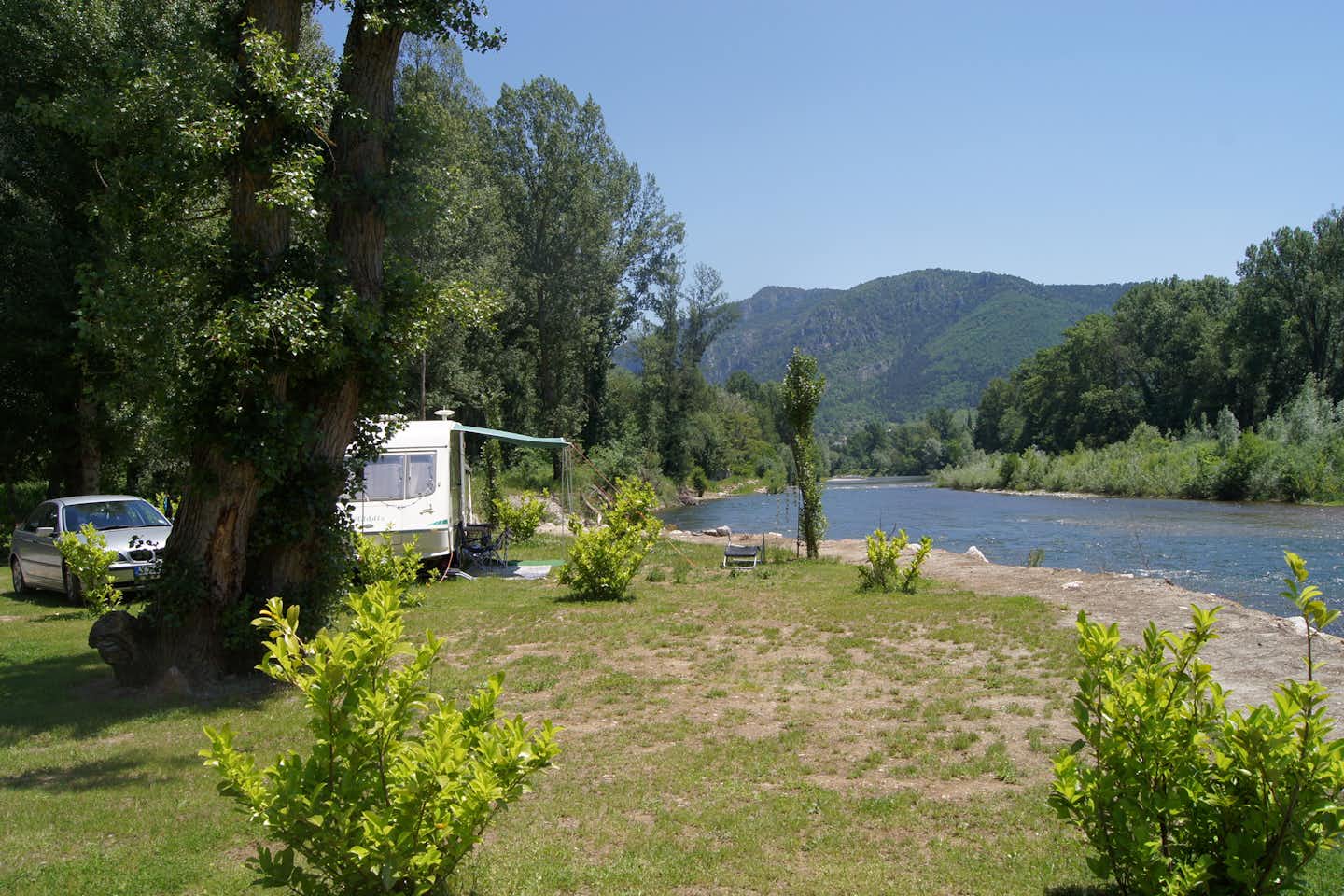 Camping Les Bords du Tarn - Stell- und Zeltplätze vom Campingplatz am Flussufer im Tal mit Blick auf die Berge   