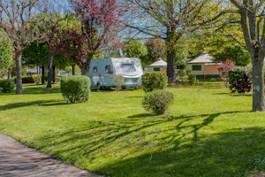 Camping Les Bruyères - Wohnmobilstellplatz zwischen Bäumen auf dem Campingplatz