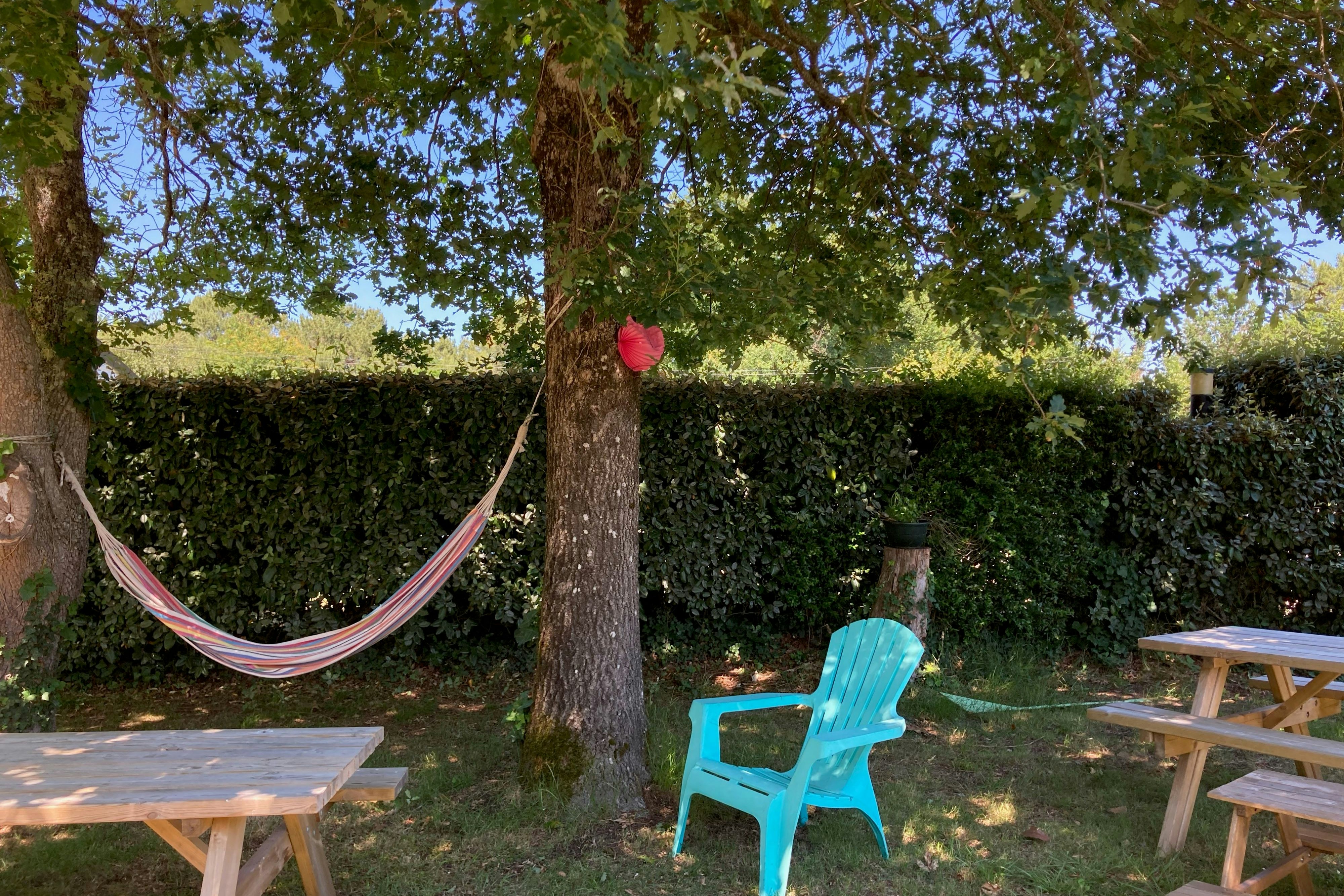 Camping Les Bruyères - Sitzecke mit Picknickbänken und Hängematte