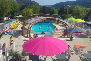 Camping Les Calquières - Blick auf Pool mit Liegestühlen und Sonnenschirmen auf dem Campingplatz