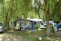 Camping Les Catalpas - Wohnwagen mit Vorzelt unter Bäumen
