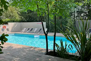 Camping Les Cent Chênes - Pool mit Liegestühlen am Campingplatz