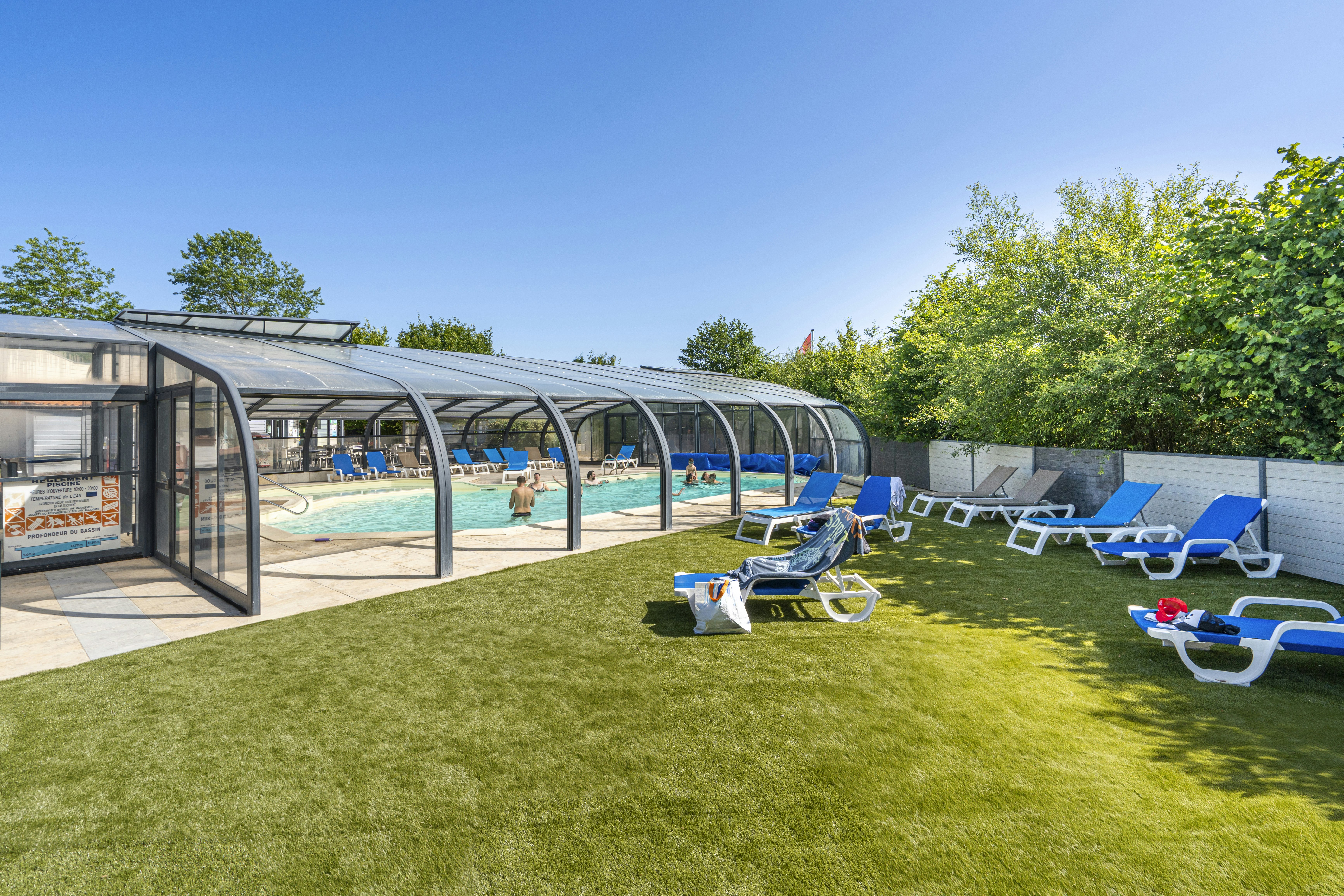 Camping Les Charmes - Überdachter Pool mit Liegestühlen auf dem Campingplatz