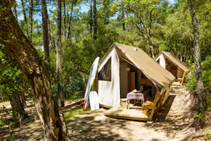 Camping Les Chevreuils - Mobilheime vom Campingplatz mit Veranden zwischen Bäumen