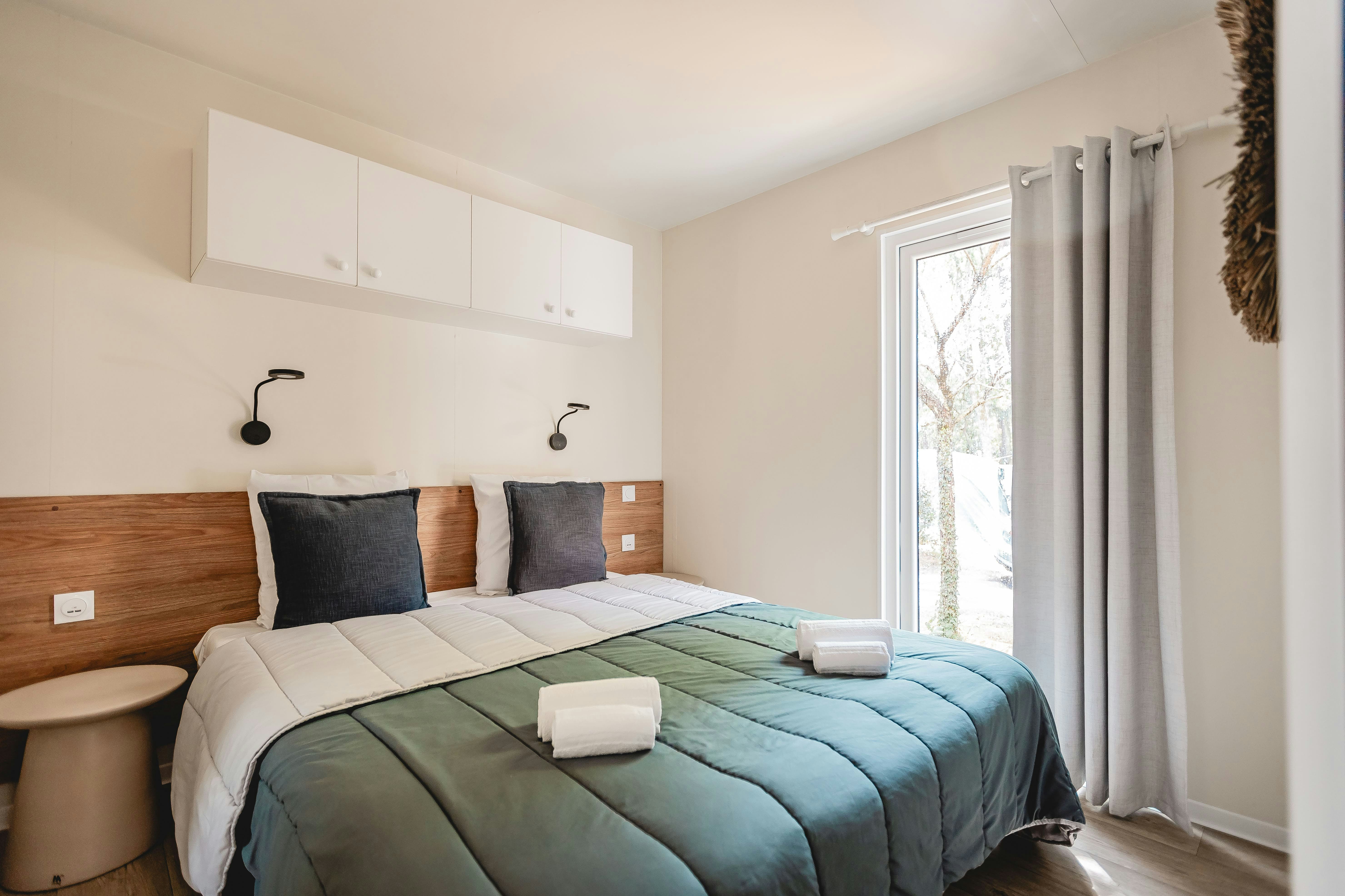 Les Maritimes  Camping Les Chevreuils  - Doppelbett im Schlafzimmer eines Mobilheims