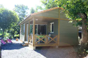 Camping Les Châtaigniers - Holzhütte mit Veranda auf dem Campingplatz mit Sonnenliegen davor