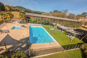 Camping les Cinq Châteaux - Blick auf die Poolanlage mit Planschbecken, Sonnenliegen und Sonnensegel