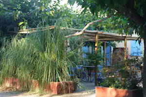 Camping Les Deux Rhône - Pavillion mit Sitzgelegenheiten und Beeten auf dem Zeltplatz