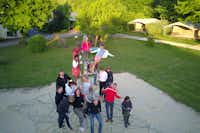 Camping Les Deux Vallées - Gäste des Campingplatzes auf dem grünen Spielplatz für Kinder