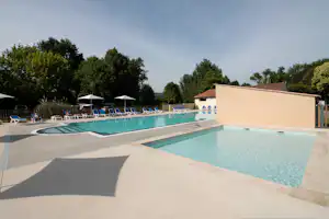 Camping Les Deux Vallées - Poolbereich mit Planschbecken und Liegestühlen auf dem Campingplatz