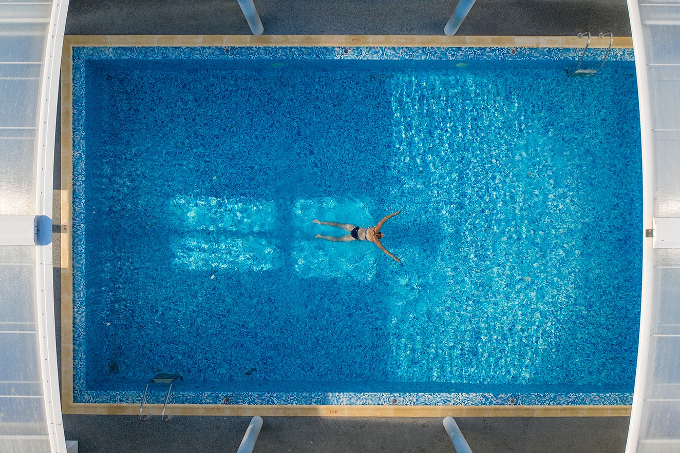 Camping Les Genêts - Person schwimmt im Pool des Campingplatzes