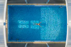 Camping Les Genêts - Person schwimmt im Pool des Campingplatzes