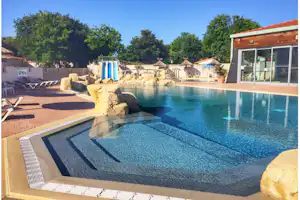 Camping Les Gros Joncs - Pool vom Campingplatz mit Wasserrutsche, Sonnenschirmen und Liegestühlen