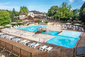 Camping Les Grottes de Roffy - Pool mit Liegestühlen und Sonnenschirmen auf dem Campingplatz
