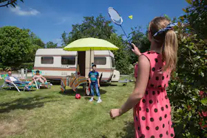 Camping Les Ilots de St. Val - Kinder spielen Badminton auf dem Rasen vor dem Wohnwagen