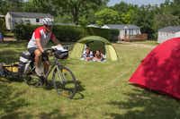 Camping Les Ilots de St. Val - Zeltplätzeund ein Radfahrer auf dem Campingplatz