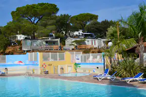 Camping Les Lauriers Roses - Überblick vom Campingplatz mit Pool, Mobilheimen und Wohnwagen- und Zeltstellplatz zwischen Bäumen