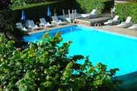 Camping Les Lavandes - Poolbereich mit Liegestühlen und Sonnenschirmen