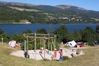 Camping Les Mouettes  -  Spielplatz vom Campingplatz mit Blick auf den See und die Berge