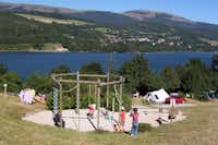 Camping Les Mouettes  -  Spielplatz vom Campingplatz mit Blick auf den See und die Berge
