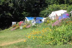 Camping Les Mouettes - Zeltplatz vom Campingplatz umgeben von Bäumen und Blumenbeeten