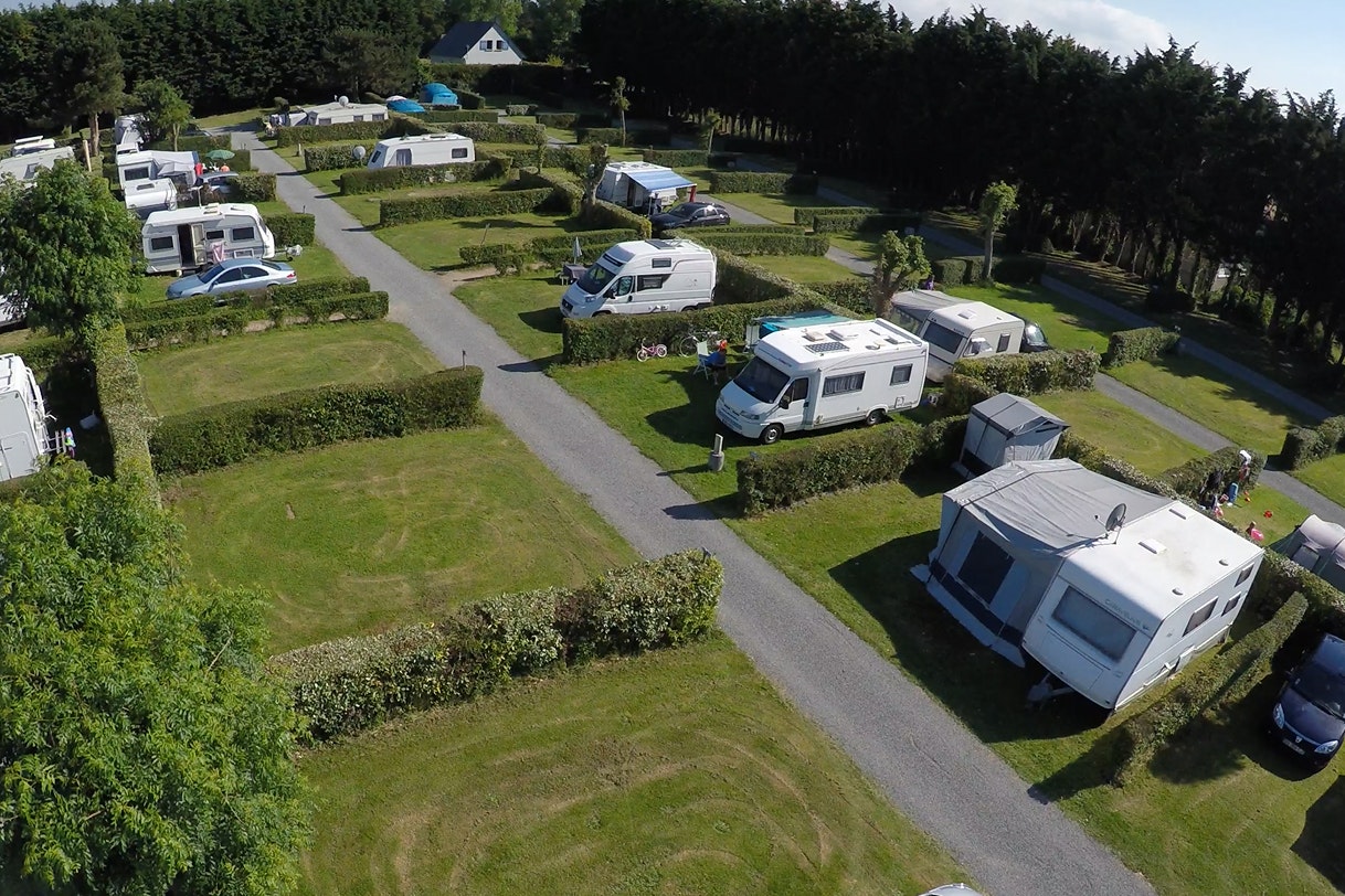 Camping Seasonova Les Mouettes  Camping Les Mouettes - Blick auf die Standplätze getrennt durch Hecken auf grüner Wiese