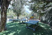Camping les Oliviers  -  Spielplatz mit Tischtennisplatten unter Bäumen