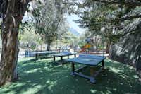 Camping les Oliviers  -  Spielplatz mit Tischtennisplatten unter Bäumen