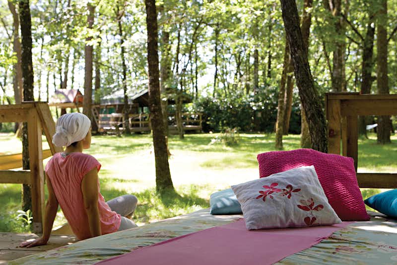 Camping Les Ormes  -  Camper auf der Veranda vom Mobilheim auf dem Campingplatz im Grünen