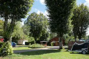 Camping Les Pêcheurs Blick auf Standplätze, das kleine Rezeptionsgebäude und Mobilheim im Hintergrund