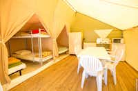 Camping Les Peupliers - Innenraum eines Glamping Zelts mit Betten und Sitzgelegenheiten