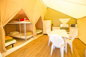 Camping Les Peupliers - Innenraum eines Glamping Zelts mit Betten und Sitzgelegenheiten