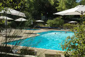 Camping Les Pialades - Swimmingpool mit Liegestühlen und Sonnenschirmen am Rand