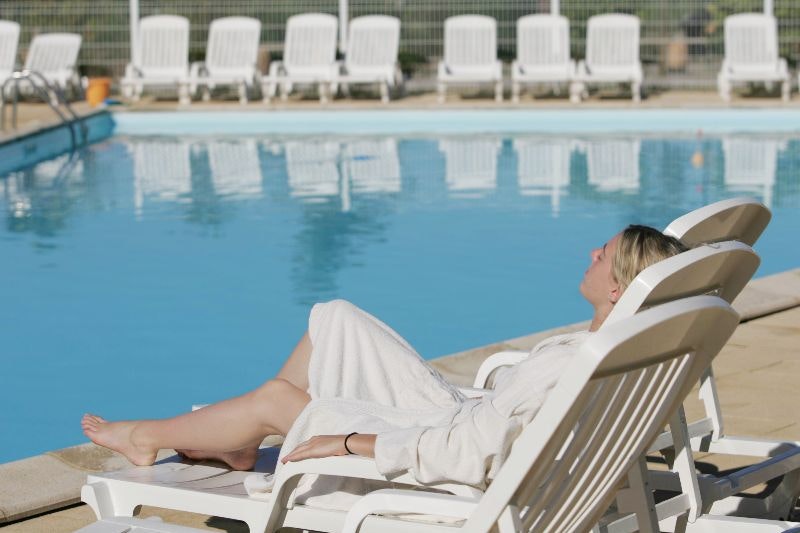 Camping Les Pins du Soleil - Der Gast liegt am Pool in der Sonne